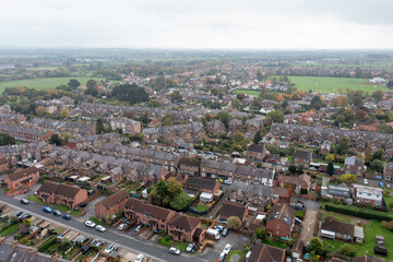 Naklejka premium Aerial drone photo of the market town of Thirsk in North Yorkshire, England showing rows of victorian terrace houses and homes on a gloomy dark bad weather rainy day in the winter time