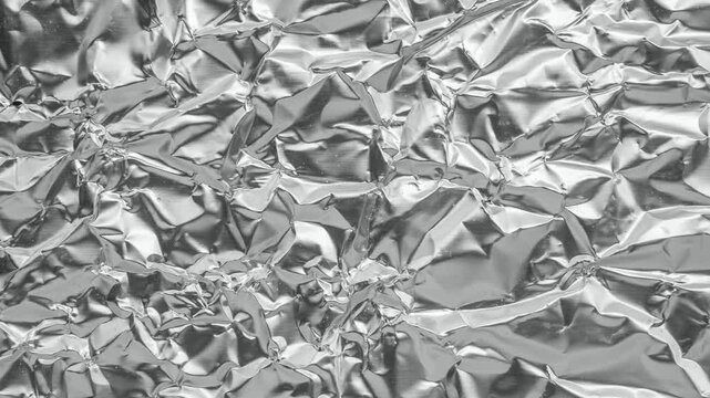 Shiny metal silver gray foil leaf crumpled texture background stop motion