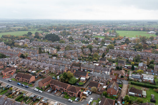 Aerial drone photo of the market town of Thirsk in North Yorkshire, England showing rows of victorian terrace houses and homes on a gloomy dark bad weather rainy day in the winter time