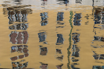distorted building reflections on rippled water surface