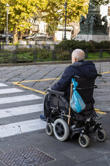 man in motorized wheelchair at pedestrian crossing