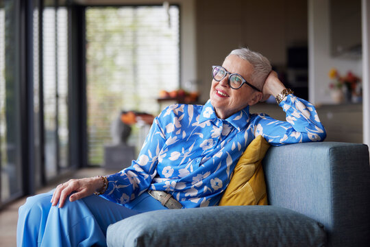 Relaxed senior woman sitting on couch at home