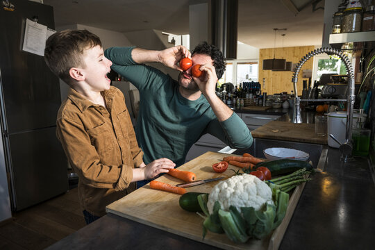 Father and son having fun while cooking together in the kitchen