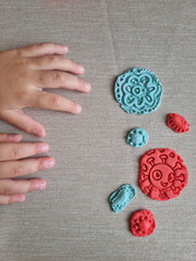 Covid and other respiratory virus molecules made of plasticine. Little toddler education moment in a playful mode. Bacteria made of playdough and kids' hands over the table. 