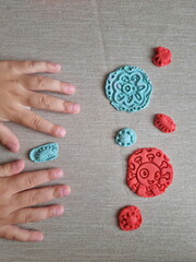Covid and other respiratory virus molecules made of plasticine. Little toddler education moment in a playful mode. Bacteria made of playdough and kids' hands over the table. 
