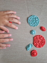 Covid and other respiratory virus molecules made of plasticine. Little toddler education moment in a playful mode. Bacteria made of playdough and kids' hands over the table. 