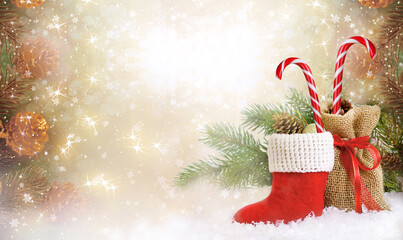 Christmas background with decorative Santa's red boot, candy cane lollipop and gift bag, branch and pine cones for tree decoraton. New Year winter holidays fantasy concept with decor and copy space.