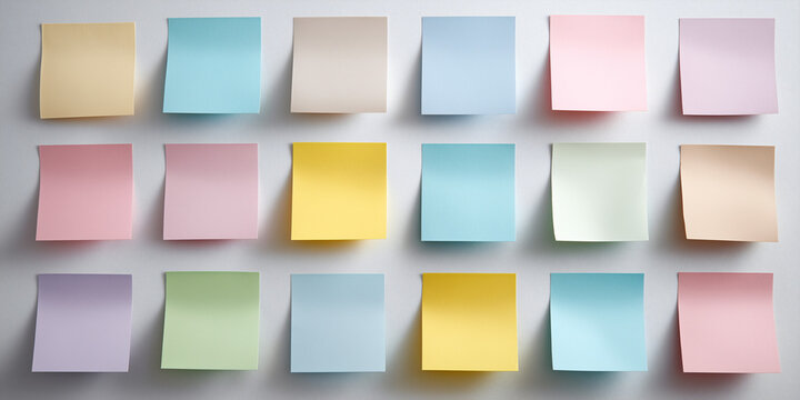A collection of various colored sticky notes attached to a smooth surface
