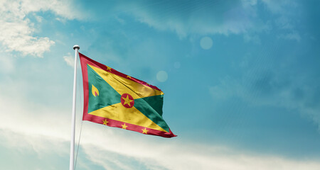 Grenada national flag fluttering. The flag blowing in beautiful soft sky. Grenada national flag for independence day.