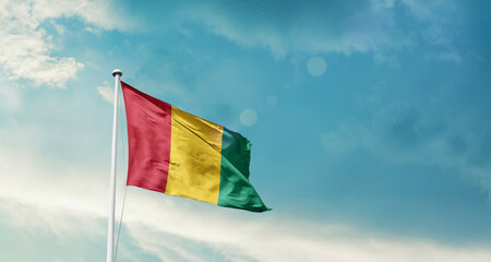 Guinea national flag fluttering. The flag blowing in beautiful soft sky. Guinea national flag for independence day.