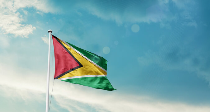 Guyana national flag fluttering. The flag blowing in beautiful soft sky. Guyana national flag for independence day.