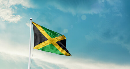 Jamaica national flag fluttering. The flag blowing in beautiful soft sky. Jamaica national flag for independence day.