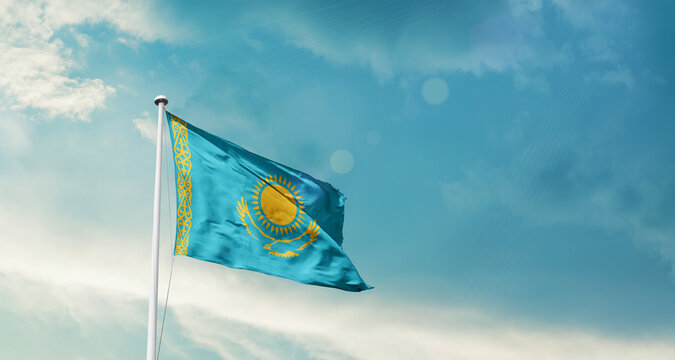 Kazakhstan national flag fluttering. The flag blowing in beautiful soft sky. Kazakhstan national flag for independence day. - Powered by Adobe