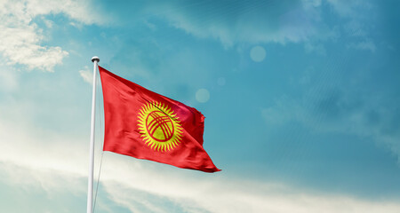 Kyrgyzstan national flag fluttering. The flag blowing in beautiful soft sky. Kyrgyzstan national flag for independence day.
