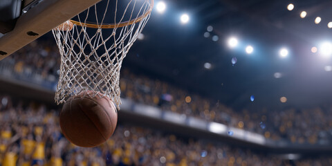 A basketball falling through the net in an arena with blurred crowd in background