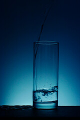 The photo shows a glass into which water is poured.