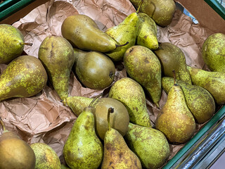 Close up of unpacked green pears on a shelf at supermarket