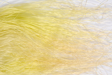 A close-up horizontal shot features a tangle of fine, pale yellow corn silk strands spread across a white background, creating a soft, hairy texture