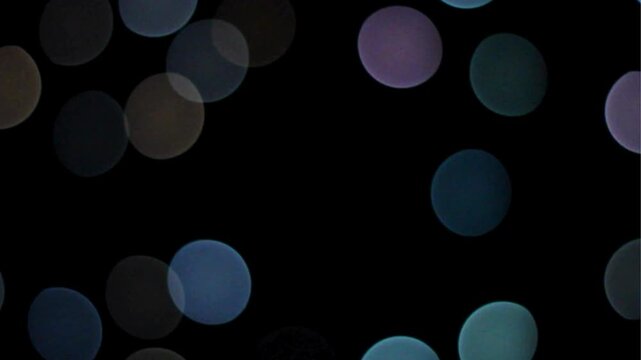 Multi Vibrant Colored balls chaotic swirling Motion on Black screen Multi-colored flashing lights of a garland in defocus Defocused shimmering multicolored glitter confetti, black background. Party, m