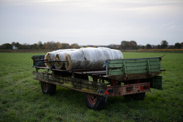 Ger&auml;te Gummiwagen auf einer Ackerbaufl&auml;che der Landwirtschaft einer Herbstlandschaft im faden, nat&uuml;rlichen Morgenlicht.