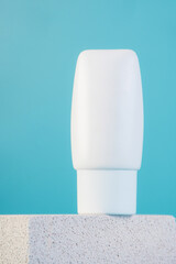 Skin care or sunscreen cosmetic with stylish props on blue background.