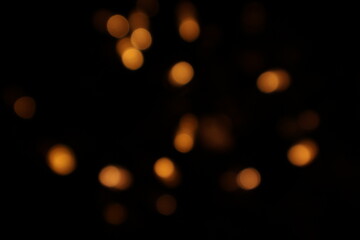 Golden blurred bokeh lights on black background. Glitter sparkle stars for celebrate. Overlay for your design. Bokeh effect golden light background. Golden Christmas concept. yellow sparkling bokeh