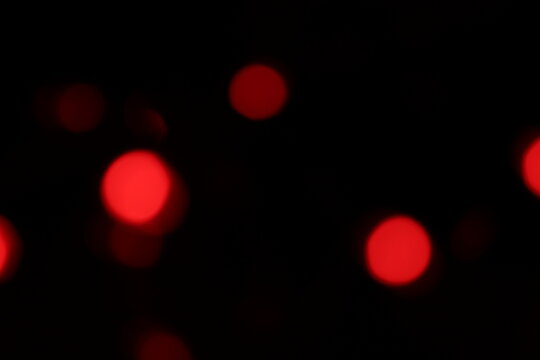 Christmas lights in bokeh. Outside in December. Red and fire red bokeh on a black background, bokeh abstract background, modern technological abstract background. Red Christmas background, Xmas