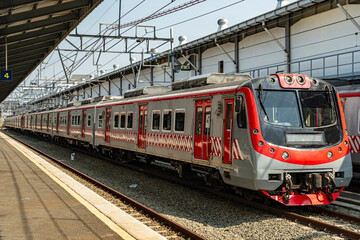 Red Commuter Train at Railway Station Platform under Bright Sunlight