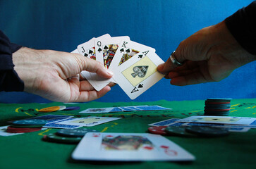 Jugador de póquer con cartas en escalera de color y tapete con fichas de apuesta y naipes