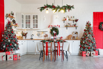 Cozy Christmas kitchen interior with decorated tree, table, candles, and festive garland