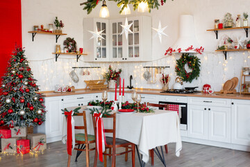 Cozy Christmas kitchen interior with decorated tree, table, candles, and festive garland