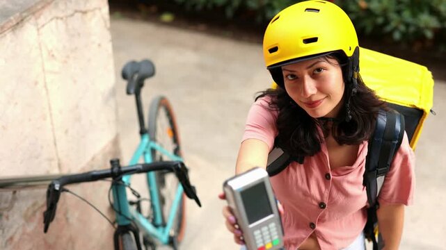 Delivery woman using pos terminal for payment - Powered by Adobe