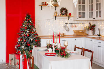 Cozy Christmas kitchen interior with decorated tree, table, candles, and festive garland