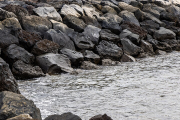Waves of the Atlantic Ocean wash over the black volcanic rocks on the shore. Tenerife, Canary Islands.