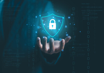 Businessman holding digital shield with padlock icon, representing cybersecurity, data protection, privacy, and secure information network in modern technology and online business concept.