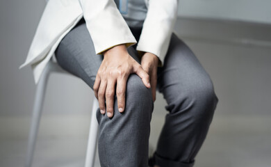 A woman supporting herself from numbness, muscle weakness, pain, and tingling in the knee nerve endings.