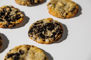 A close-up view of cookies baked with crushed chocolate sandwich cookies on a clean white background, showing texture and golden edges. No visible branding