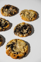 A close-up view of cookies baked with crushed chocolate sandwich cookies on a clean white background, showing texture and golden edges. No visible branding