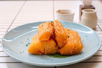Golden fried cassava served on a light blue plate with white background. Perfect for restaurant menu design, tropical food promotion, or culinary asia traditional snacks.