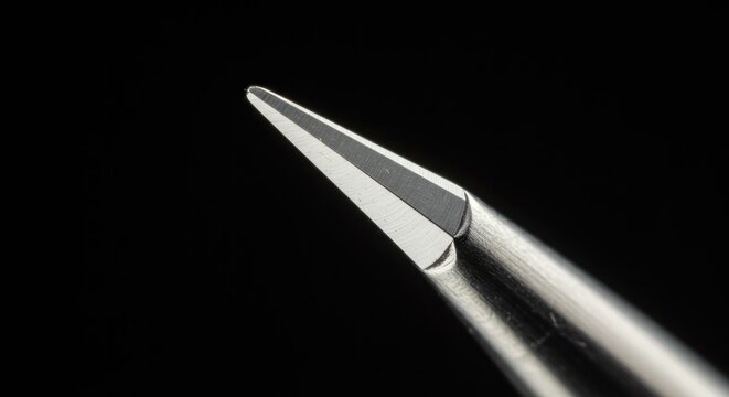 Sharp precision tip glistening against dark backdrop perfect for detailed work or focused attention concepts