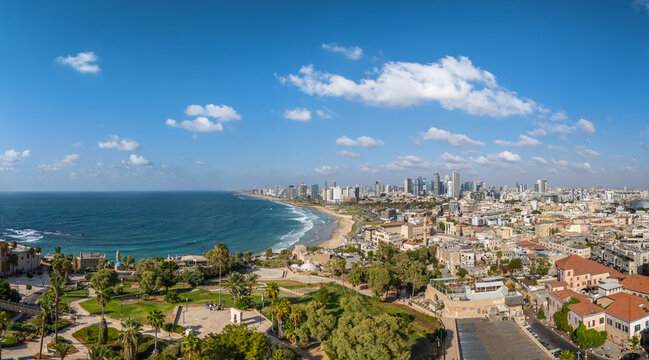 Aerial view of the ancient port city of Old Jaffa meeting the modern skyline of Tel Aviv across a sandy beach, Tel Aviv-Yafo, Israel.