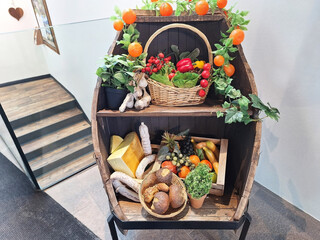 Decorating a store with plastic fruits, vegetables, cheese. A display case with plastic food.