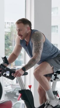 Fitness, man and cycling in spin class with bike for endurance workout, training and wellness. Person, group or energy in gym with stationary bicycle for speed challenge, cardio exercise or mobility.