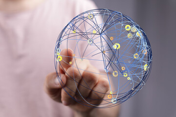 Close-up of a hand holding a digital globe representing global networking, connectivity, and...