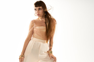 Young woman in stylish outfit poses confidently against bright background