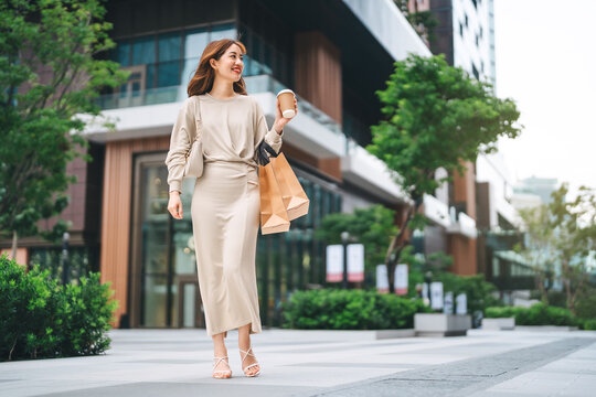 Single adult business asian woman holding coffee cup and shopping bag on black friday sale city people lifestyle