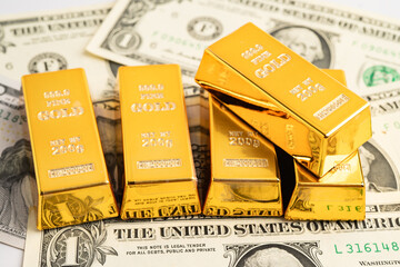 Gold bars on US dollar banknote money, finance trading investment business currency.