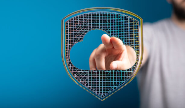 Abstract image of cloud security and data protection. Person pointing to shield with a cloud shape to represent secure online data st