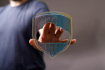 A man's hand holding a shield with cloud symbol, representing data security, network, online...