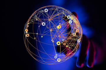 Abstract image depicting a network of interconnected points forming a sphere held by a hand. Represents globalization, communication